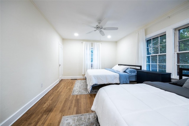 bedroom featuring hardwood / wood-style floors, ceiling fan, and crown molding