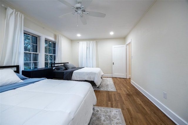 bedroom featuring wood-type flooring, ceiling fan, and ornamental molding