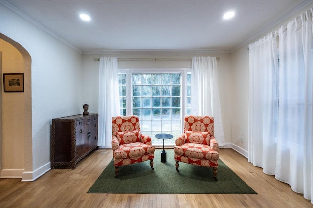 living area with hardwood / wood-style floors and ornamental molding