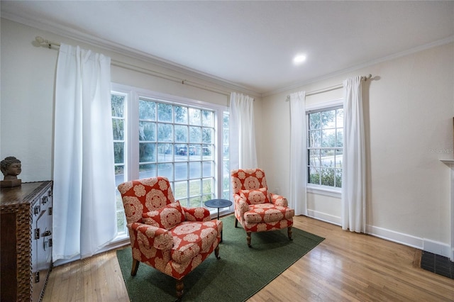 sitting room featuring ornamental molding and hardwood / wood-style flooring