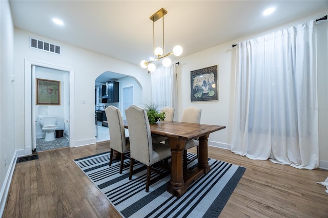 dining space featuring hardwood / wood-style floors and a notable chandelier