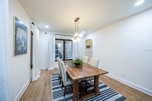 dining space with a chandelier and light hardwood / wood-style flooring