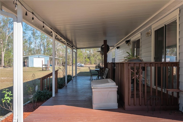 wooden deck featuring a porch and a yard