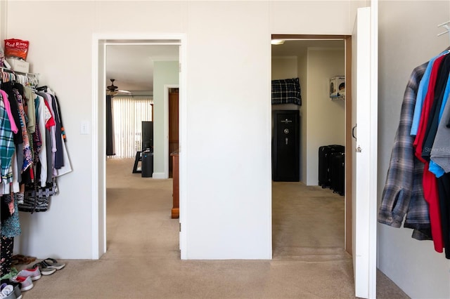 spacious closet with ceiling fan and light colored carpet