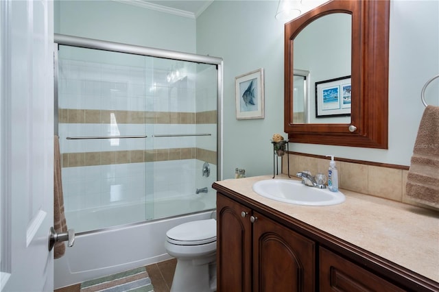 full bathroom with tile patterned floors, bath / shower combo with glass door, toilet, vanity, and ornamental molding