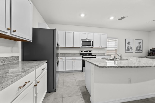 kitchen with light stone countertops, sink, stainless steel appliances, white cabinets, and light tile patterned flooring