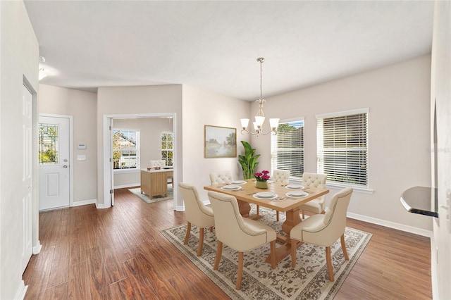 dining space featuring dark hardwood / wood-style flooring and an inviting chandelier