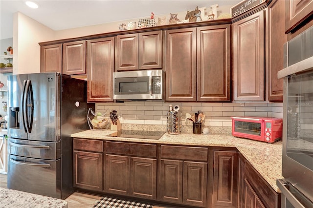 kitchen featuring light stone countertops, stainless steel appliances, and tasteful backsplash