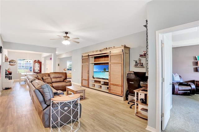 living room with ceiling fan and light hardwood / wood-style flooring