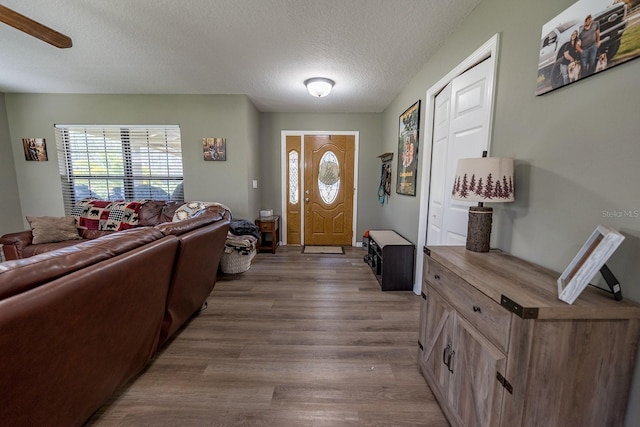 entryway with ceiling fan, a textured ceiling, and hardwood / wood-style flooring