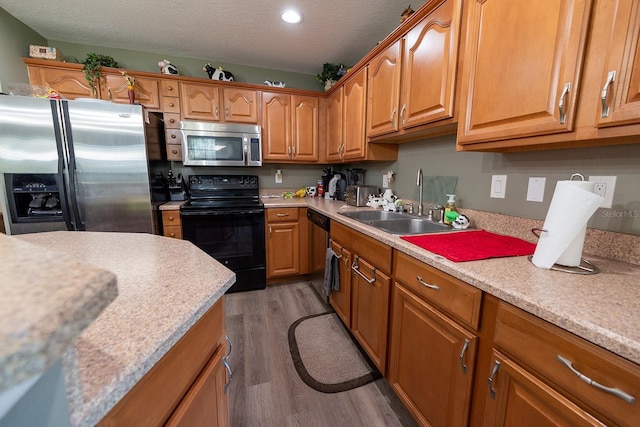 kitchen with appliances with stainless steel finishes, dark hardwood / wood-style flooring, a textured ceiling, and sink