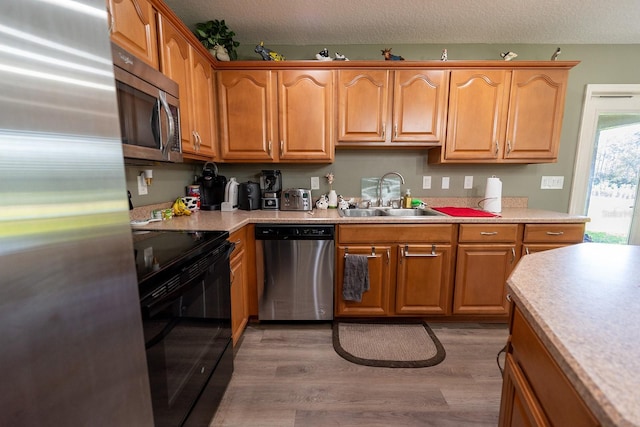 kitchen featuring a textured ceiling, dark hardwood / wood-style flooring, sink, and stainless steel appliances