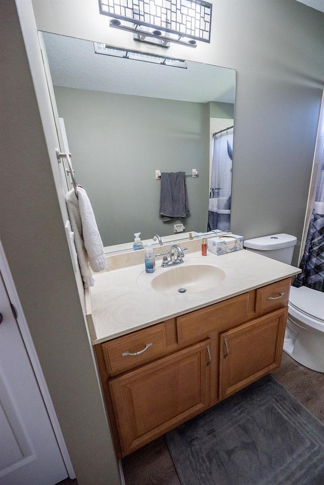 bathroom featuring hardwood / wood-style floors, vanity, toilet, and a shower with shower curtain