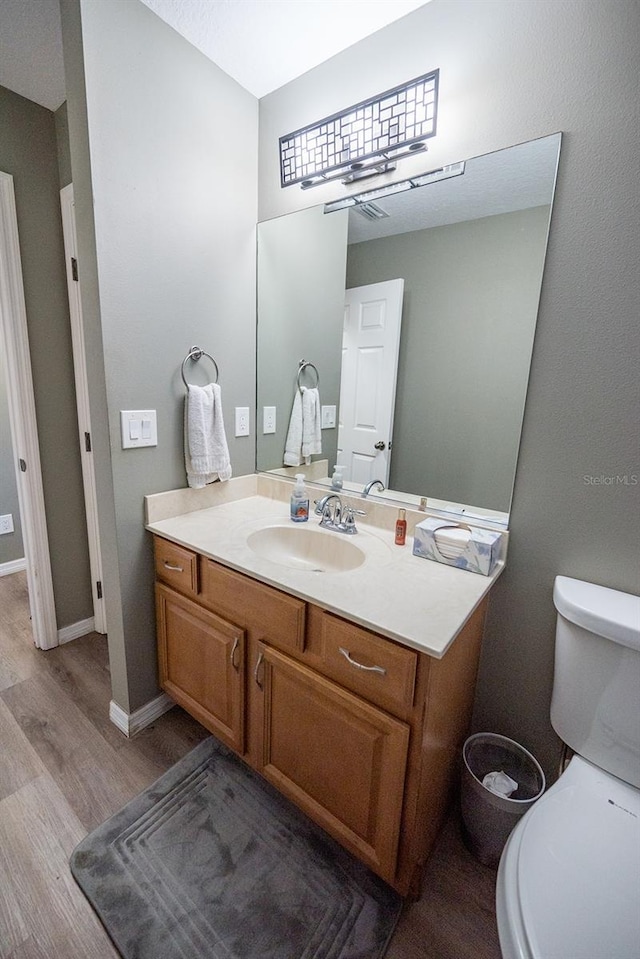 bathroom featuring hardwood / wood-style floors, vanity, and toilet