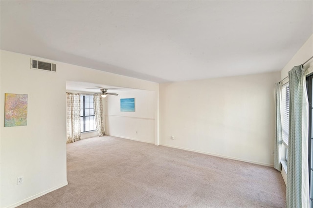 unfurnished room with light colored carpet and ceiling fan