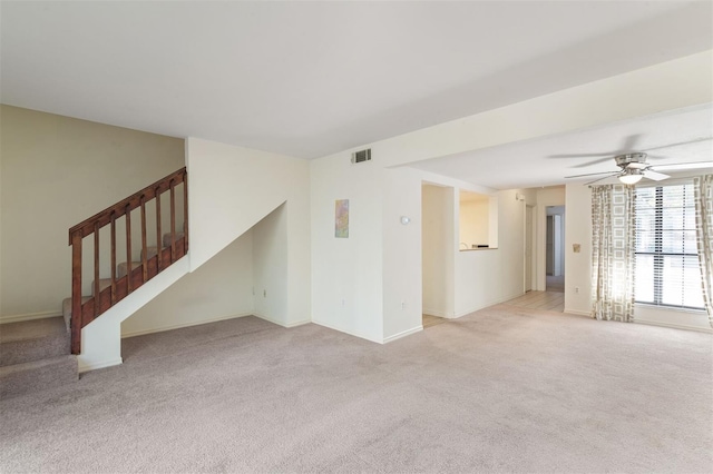 unfurnished living room featuring ceiling fan and light colored carpet