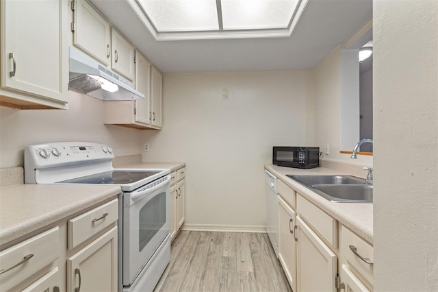 kitchen featuring sink, white appliances, and light hardwood / wood-style floors