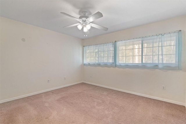 carpeted spare room featuring ceiling fan