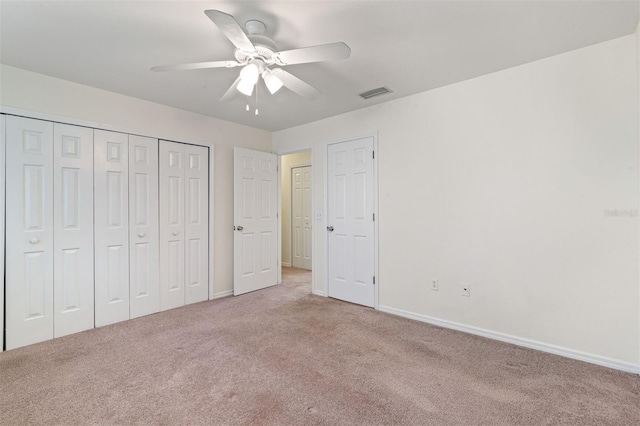 unfurnished bedroom featuring light colored carpet, a closet, and ceiling fan