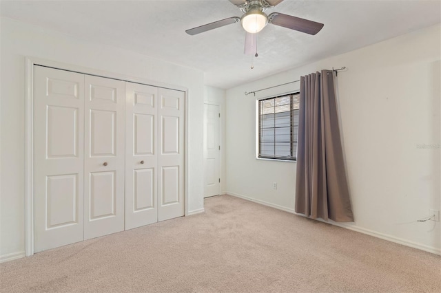 unfurnished bedroom featuring light colored carpet, a closet, and ceiling fan