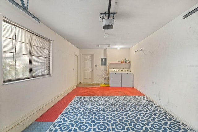 garage featuring a garage door opener, electric panel, and washer and clothes dryer