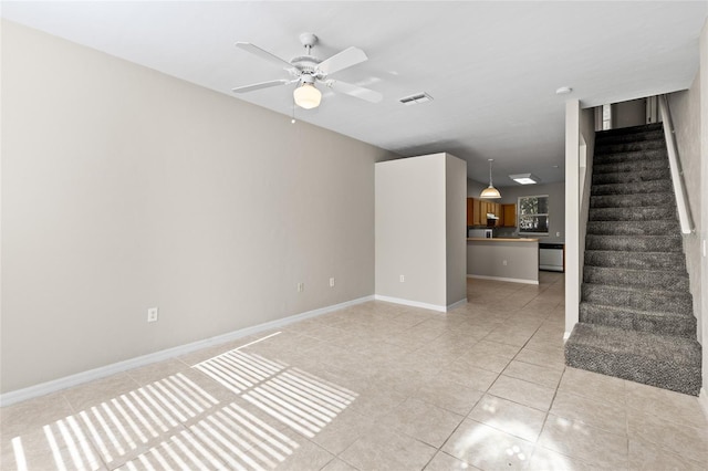 unfurnished living room featuring ceiling fan and light tile patterned floors