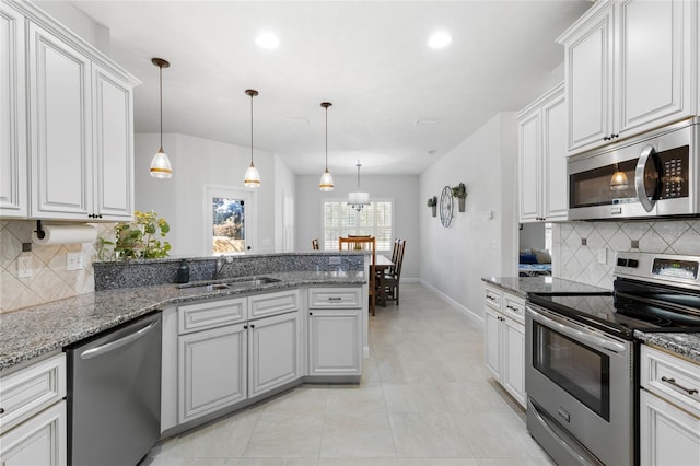 kitchen featuring white cabinets, stainless steel appliances, hanging light fixtures, and sink