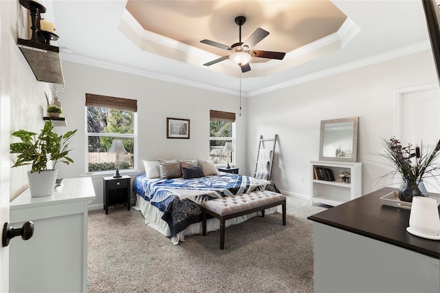 carpeted bedroom featuring ceiling fan, ornamental molding, and a tray ceiling