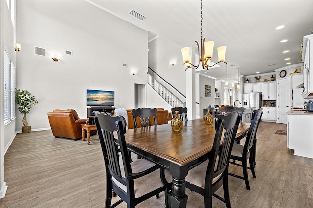 dining area with crown molding, light hardwood / wood-style flooring, and a chandelier