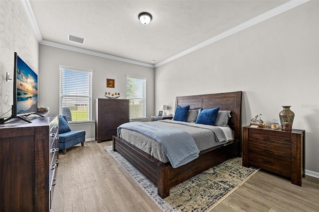 bedroom with crown molding and light wood-type flooring