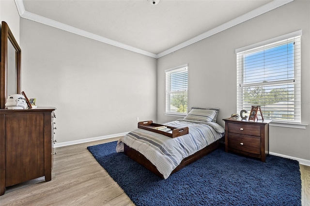 bedroom with ornamental molding and light hardwood / wood-style flooring