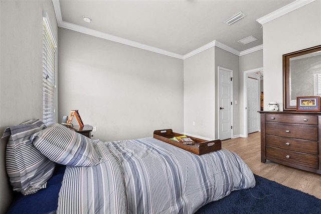 bedroom with light hardwood / wood-style floors and crown molding