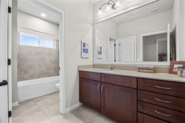 full bathroom with tiled shower / bath, tile patterned floors, vanity, and toilet