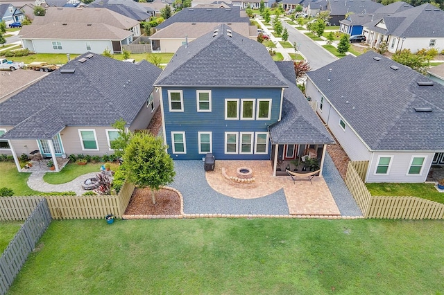 back of house with a fire pit, a patio, and a lawn