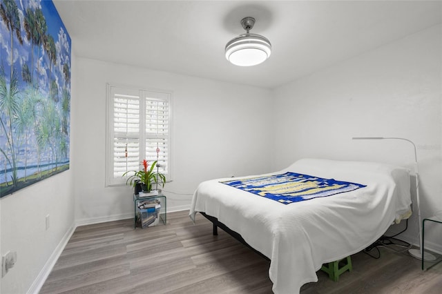 bedroom with baseboards and wood finished floors