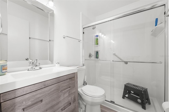 full bathroom with a shower stall, toilet, and vanity