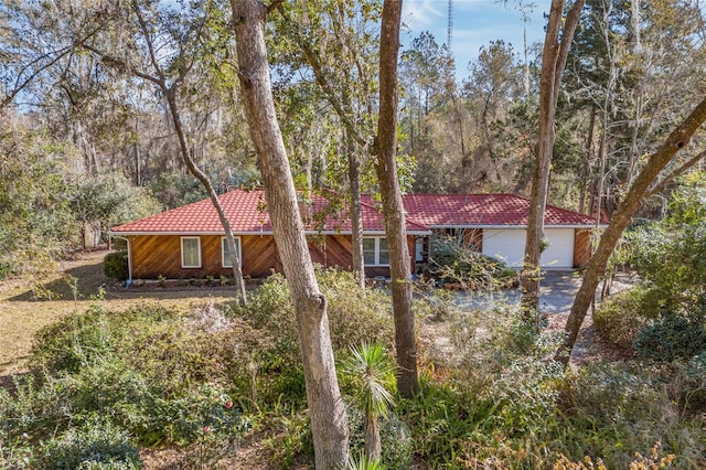 view of front of home with a garage and a tile roof