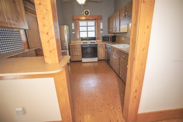 kitchen with kitchen peninsula, stainless steel appliances, and sink