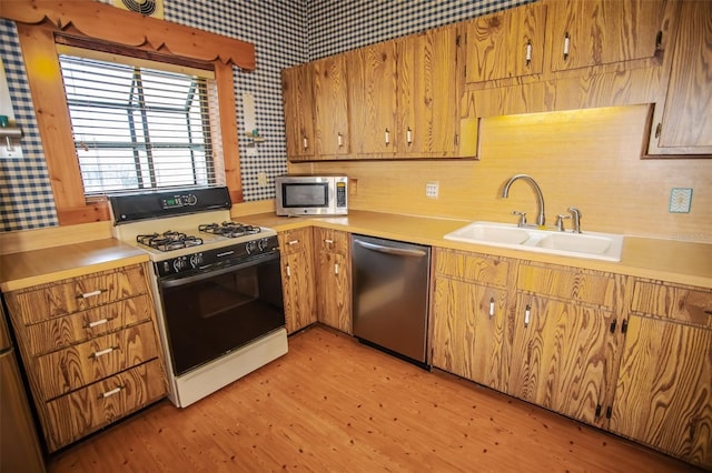 kitchen with sink, light hardwood / wood-style flooring, and appliances with stainless steel finishes