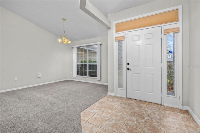 foyer entrance featuring lofted ceiling, light carpet, and a chandelier