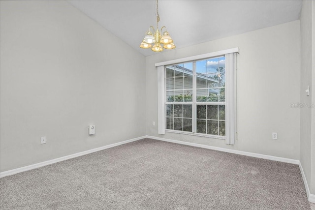 carpeted empty room with vaulted ceiling and an inviting chandelier