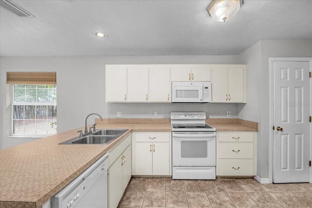 kitchen with white cabinetry, sink, kitchen peninsula, white appliances, and light tile patterned flooring