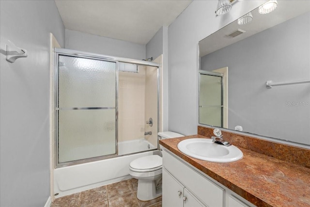 full bathroom featuring tile patterned flooring, vanity, toilet, and shower / bath combination with glass door