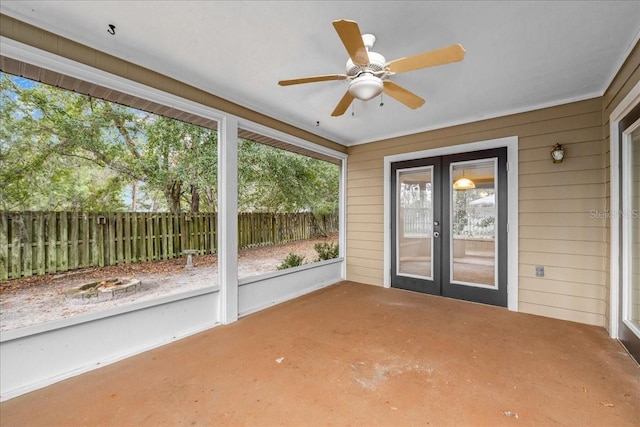 unfurnished sunroom featuring ceiling fan and french doors