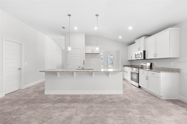 kitchen featuring hanging light fixtures, a center island with sink, white cabinets, and stainless steel appliances