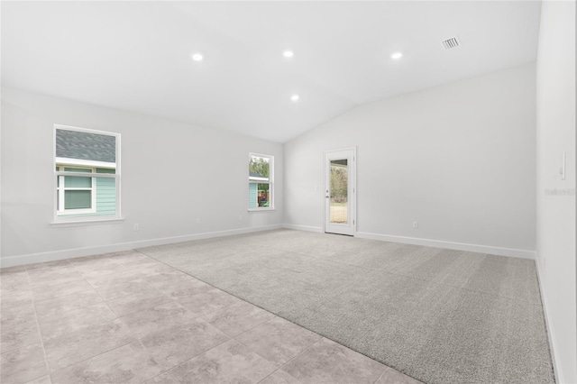 unfurnished room with light colored carpet and lofted ceiling