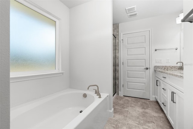 bathroom featuring vanity and independent shower and bath