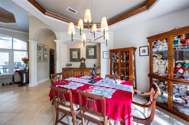 dining space with a raised ceiling, light tile patterned floors, a notable chandelier, and ornamental molding