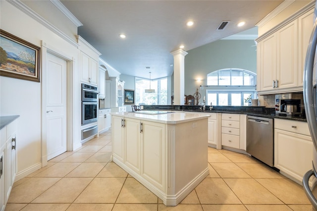 kitchen with kitchen peninsula, a kitchen island, dark stone counters, and appliances with stainless steel finishes