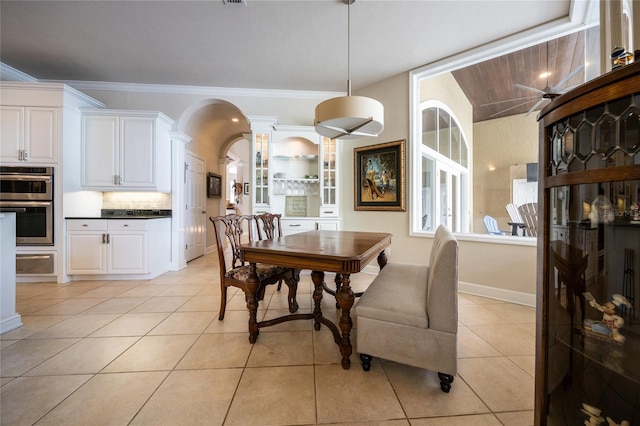 dining room featuring ornate columns, ceiling fan, ornamental molding, and light tile patterned flooring